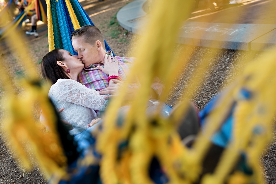A man and woman snuggle in a hammock at spruce street harbor park during their engagement session.